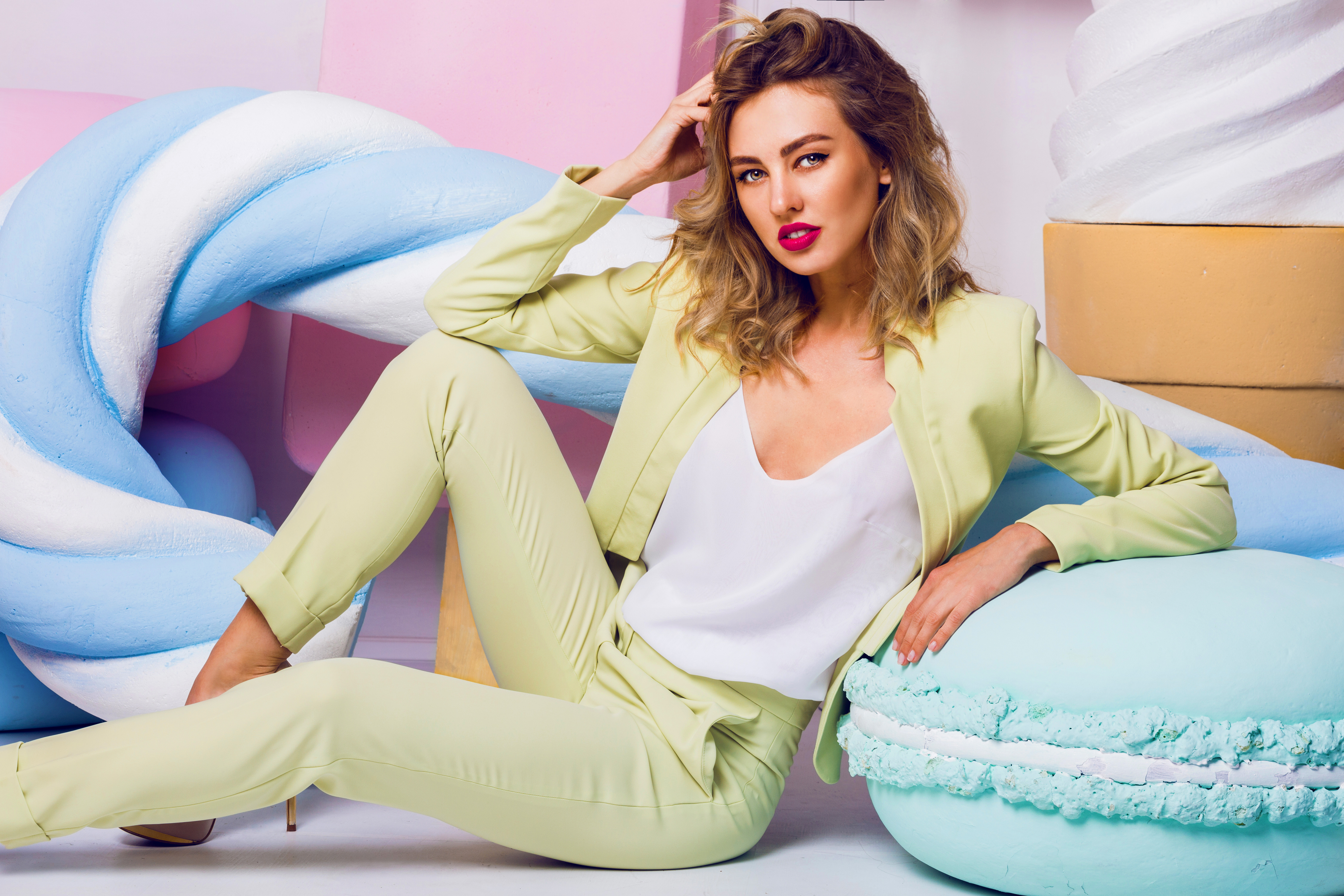 blogModacad-cores-ver-o-20-21-fashion-photo-of-sexy-beautiful-woman-with-blond-curly-hairstyle-wearing-elegant-costume-and-white-top-sitting-near-big-colorful-props-sweets-modern-young-fashionable-lady-in-pastel-colors